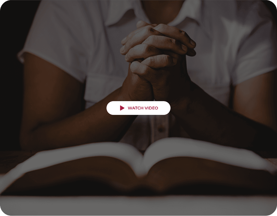 Hands praying over Bible